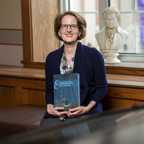 Woman in glasses holds book