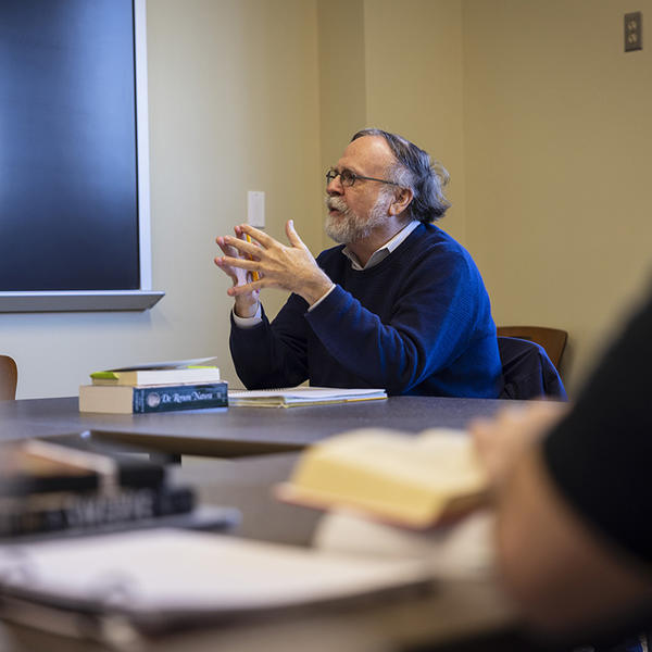 Professor John Little sits in a classroom
