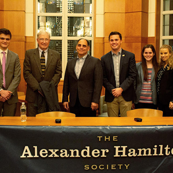 Six people in front of a banner.