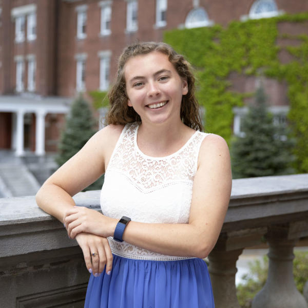 Kerry Bresnahan '22 poses on the patio of a brick building at the College of the Holy Cross.