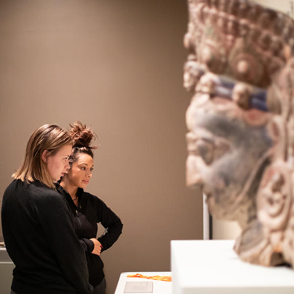 Holy Cross students are seen here admiring the objects of Buddhist devotion displayed in the Cantor Art Gallery's Dharma and Punya exhibit. Photo by Avanell Brock