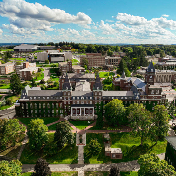 Photo taken from the sky above a college campus showing lots of green space and old brick buildings.