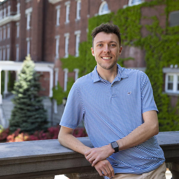 Sean Sova poses in front of a balcony at the College of the Holy Cross.