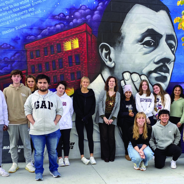 Students and professor stand in front of poet Stanley Kunitz mural in Worcester, MA.