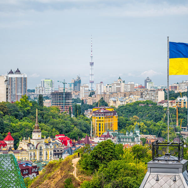 cityscape of Kiev and Ukrainian flag waving in the wind