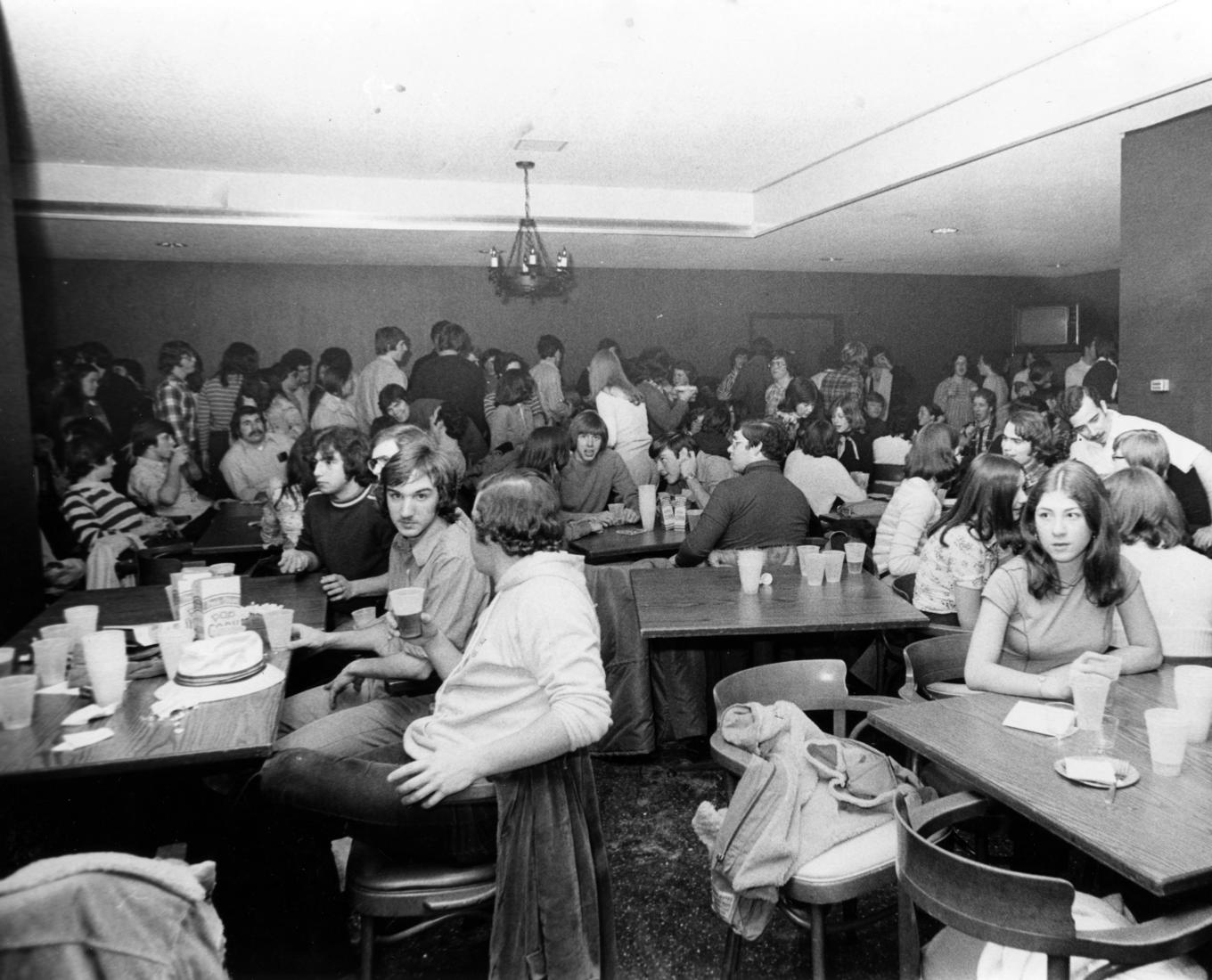 A large group of people within a dining hall or cafeteria 