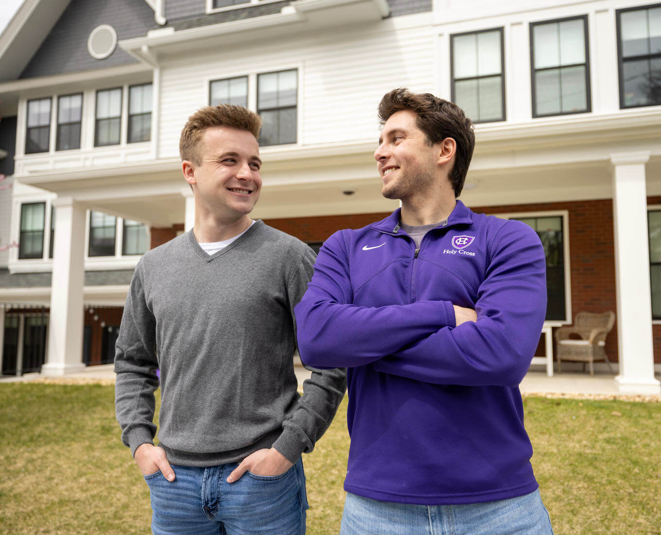 Two male college students standing outside their dorm.