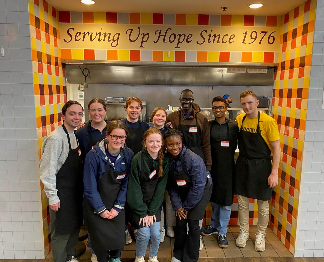 Group of college students volunteering at a soup kitchen.