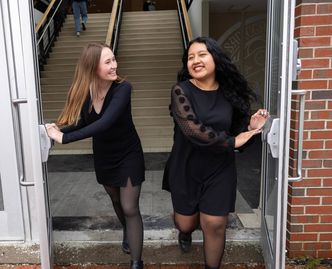 Two women walk through a door