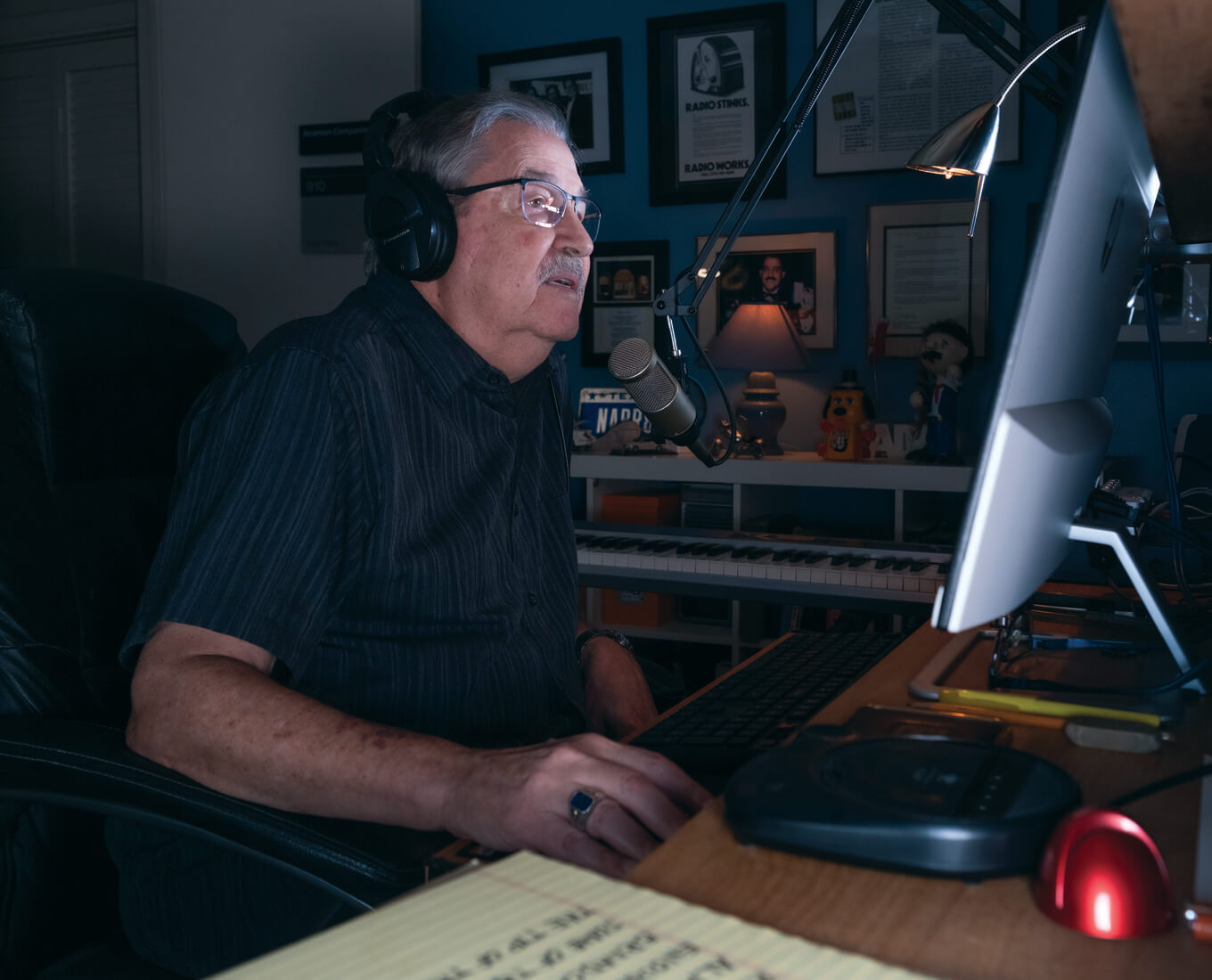 Seated man in glasses speaks into microphone