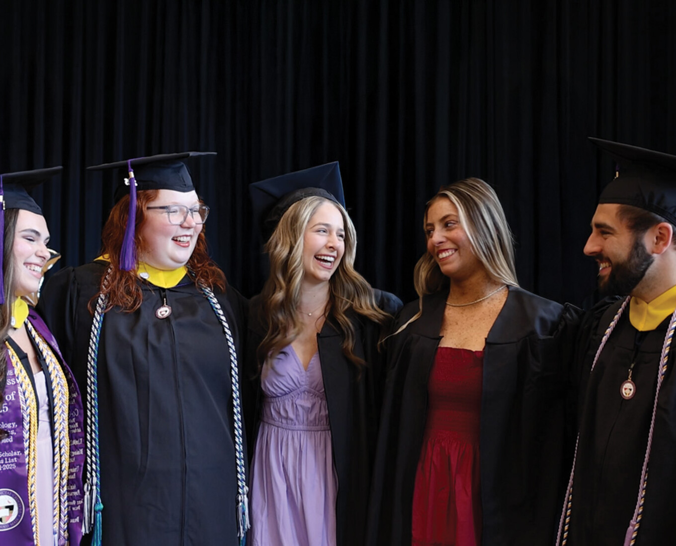 A group of Holy Cross graduates in their caps and gowns