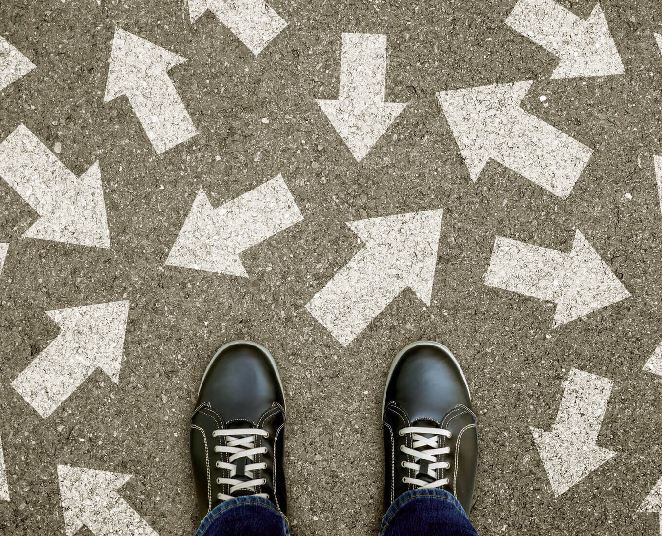 Pair of feet on a road with arrows