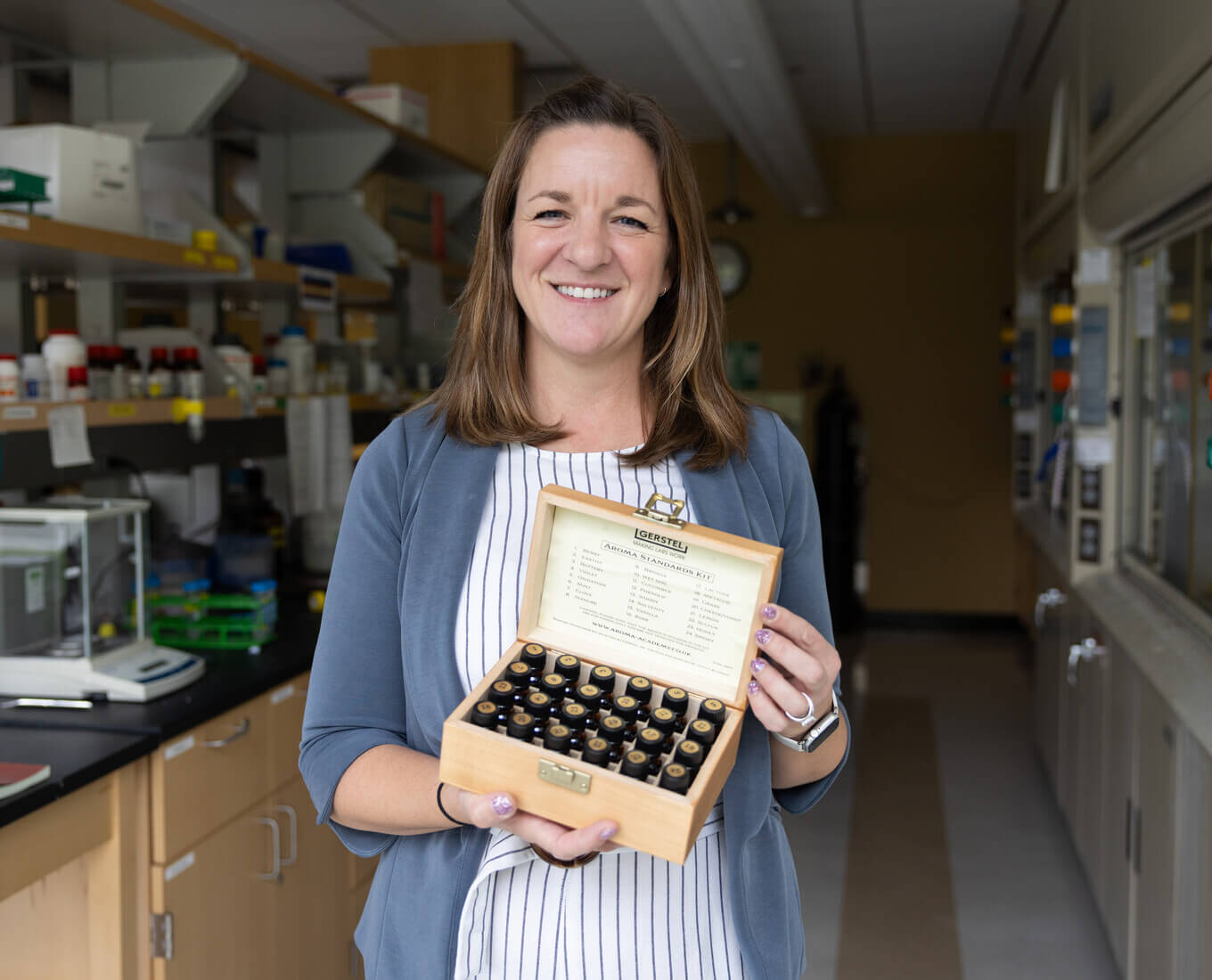 Woman holding a box containing tiny glass bottles