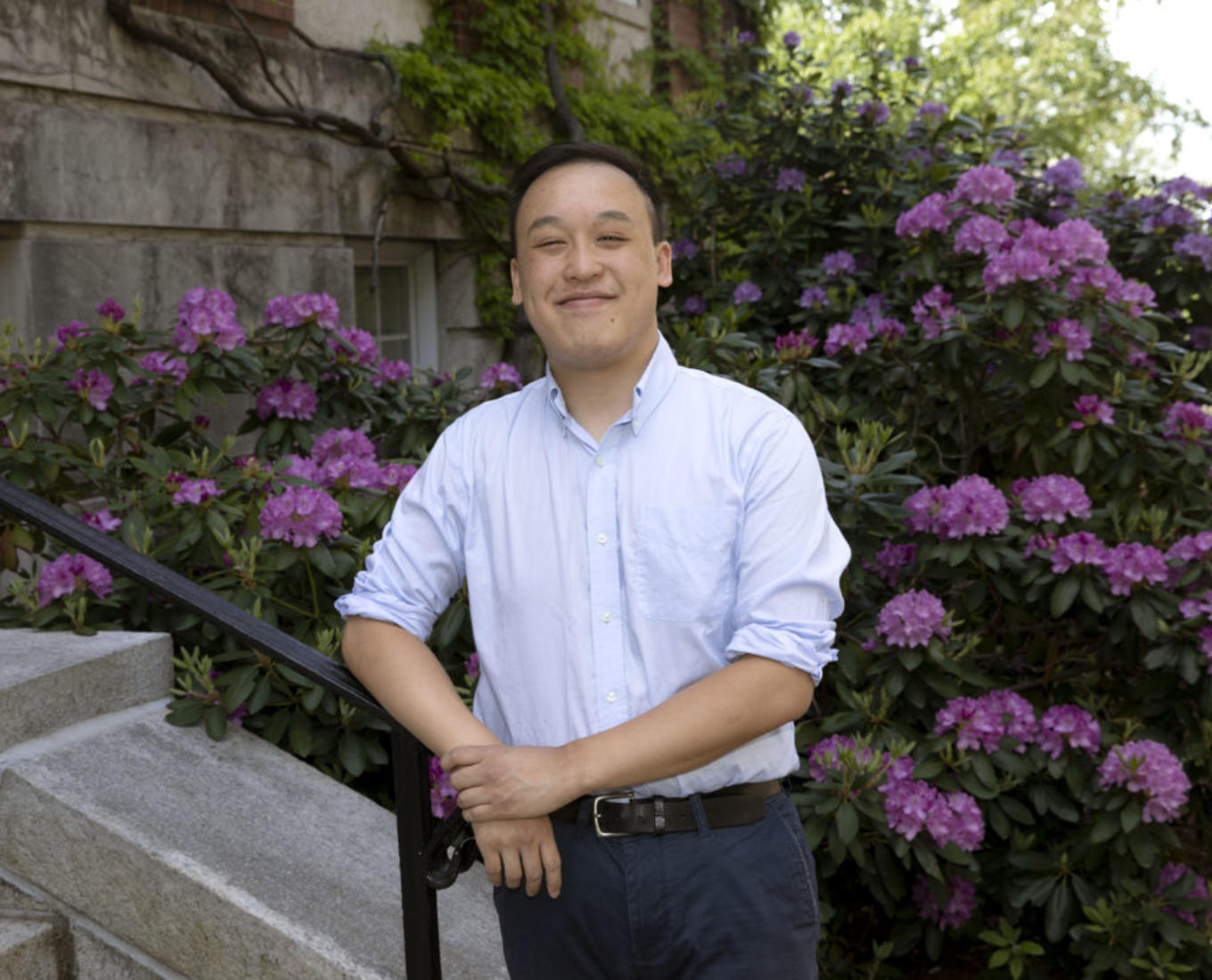 Dennis Liu, a student at the College of the Holy Cross, poses in front of flowers.
