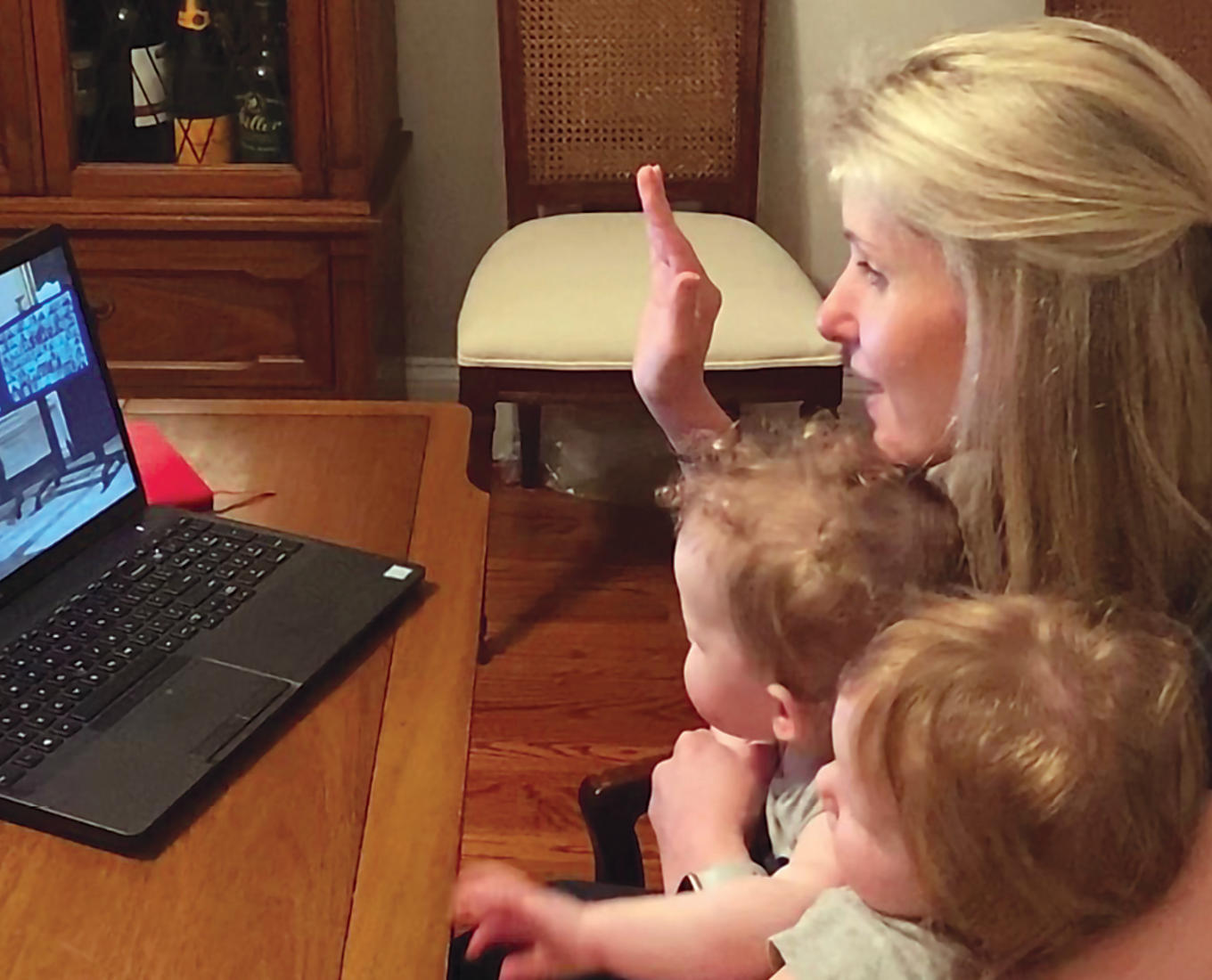 Alicia Molt-West takes her oath of office virtually, with her twin daughters seated on her lap.