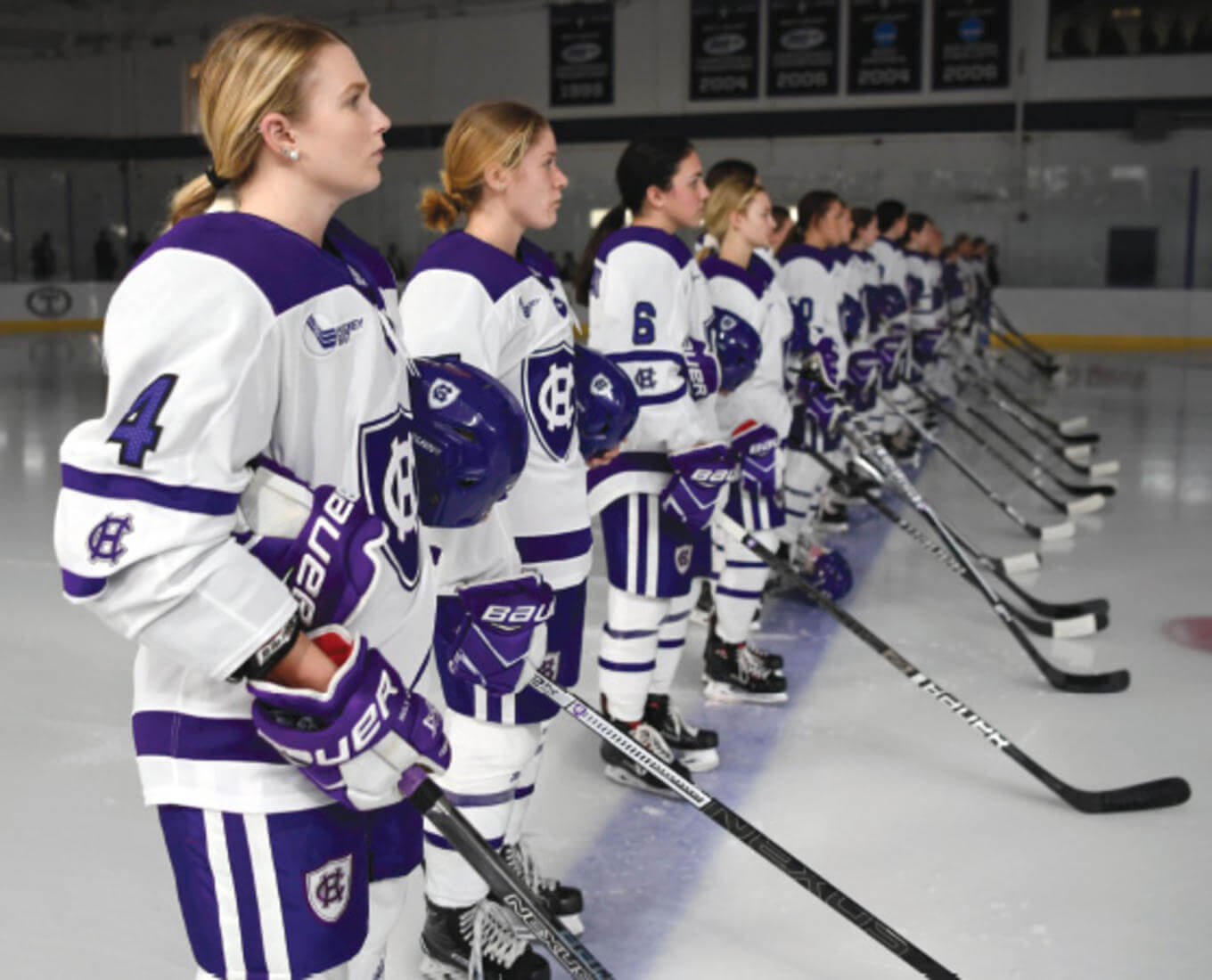 Members of the Women's Ice Hockey Team stand on the ice prior to starting a game