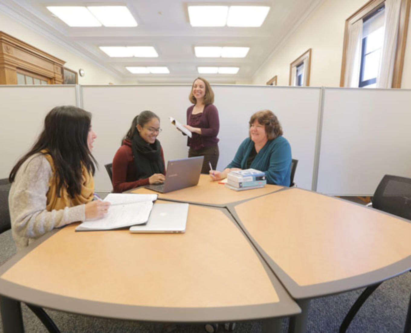 Center for Writing Director Laurie Ann Britt-Smith, far right, and Associate Director Kristina Reardon, standing, work with students on their writing