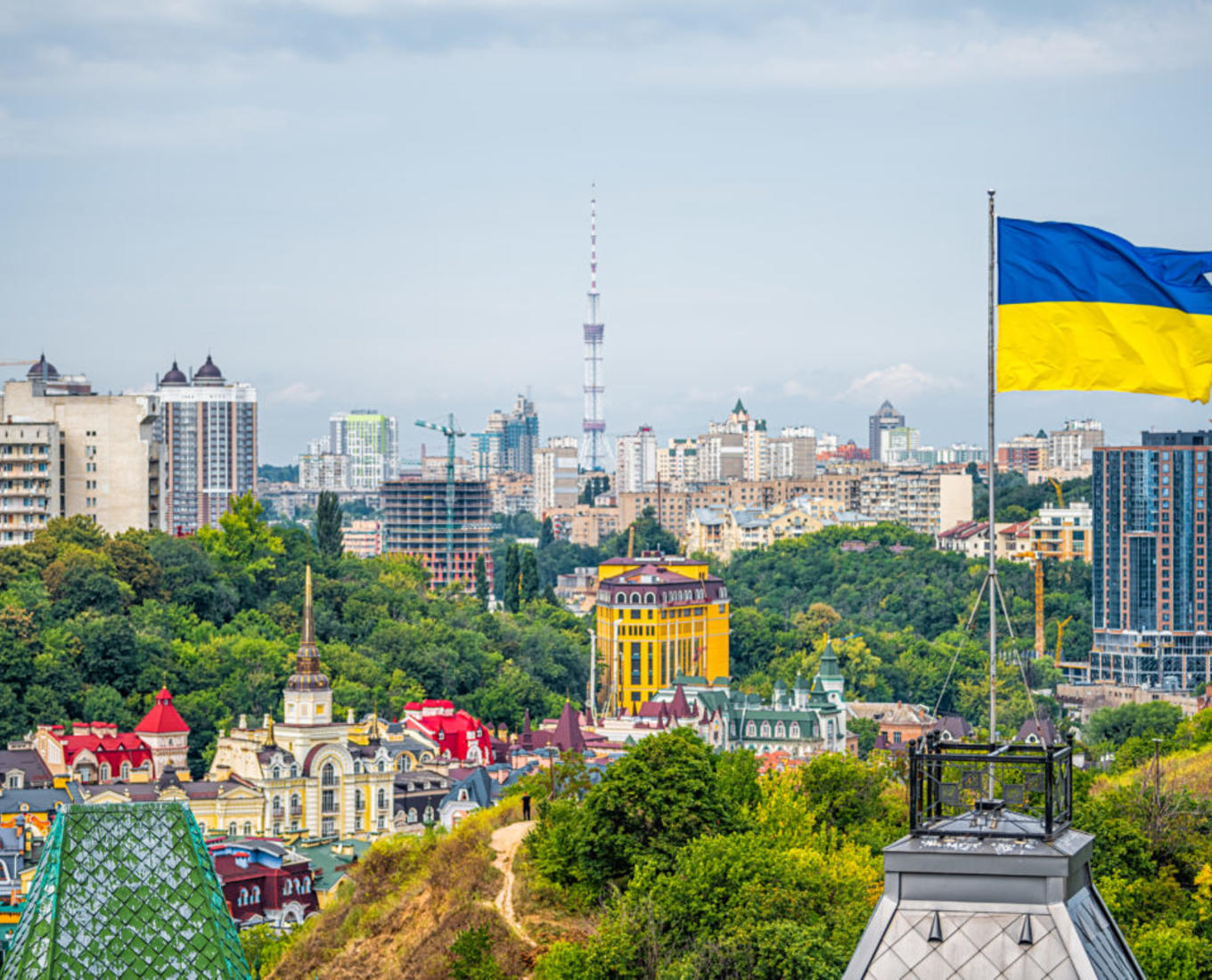 cityscape of Kiev and Ukrainian flag waving in the wind