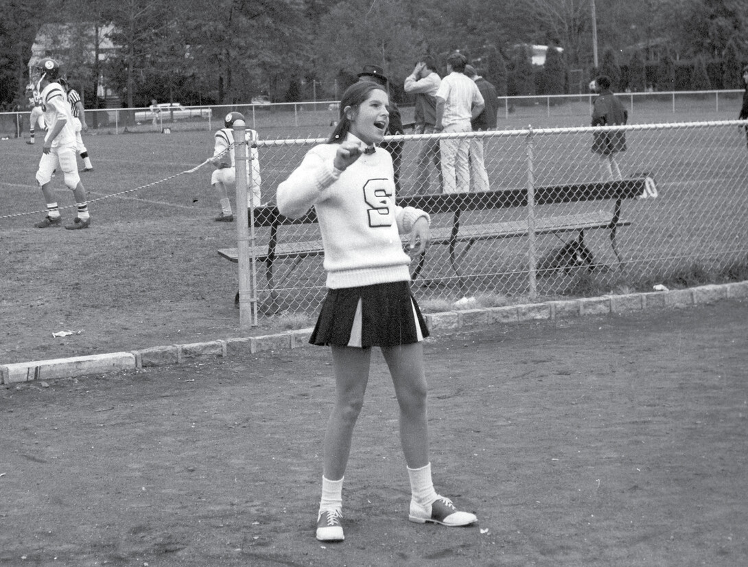 Black and white photo of Cummings in a cheerleading uniform